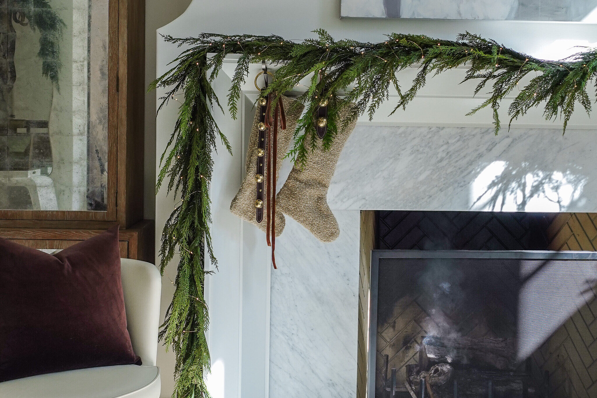 image of mantel with garland and stockings for holiday decor must-haves